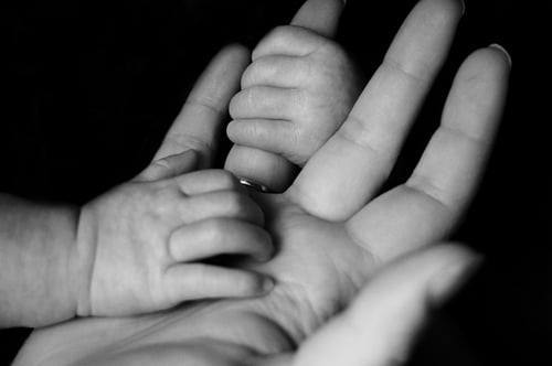 Baby hands gripping a parents fingers