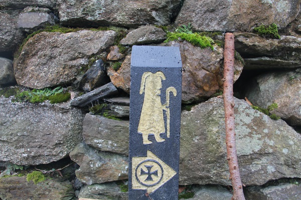 Pilgrimage milestone and a stone wall